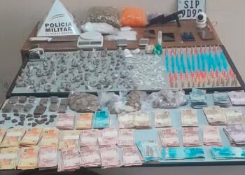 Uma mulher foi flagrada manuseando drogas dentro de casa após a Polícia Militar encontrar um pino de cocaína no bolso do marido dela na frente do imóvel, em Corinto, nesta terça-feira (25). Segundo a PM, o local onde eles moram, no Bairro Alvarenga, estaria sendo usado como boca de fumo, conforme denúncias anônimas. Com essas informações, os policiais montaram uma operação para apurar a veracidade dos fatos. Os militares flagraram o homem, de 22 anos, saindo da residência e o abordaram, encontrando a porção de cocaína. Questionado, ele negou envolvimento com o tráfico e permitiu que a PM entrasse em sua casa. Ao entrarem na residência, os policiais flagraram a mulher embalando as drogas para a comercialização. Durante buscas no local foram apreendidos: 243 pinos de cocaína, 201 buchas de maconha, meia barra e 12 porções grandes de maconha, 109 pedras de crack, três porções grandes e um pote com cocaína, três balanças, embalagens plásticas, uma câmera de vigilância, uma faca de aproximadamente, uma réplica de arma de fogo, duas rodas de bicicleta e R$ 12.452,75 em dinheiro. Conforme a PM, uma moto que estava sendo usada para o delivery de entorpecentes também foi aprendida. Diante dos fatos, os dois foram presos em flagrante por tráfico de drogas e associação para o tráfico. A ocorrência foi encaminhada para a delegacia da Polícia Civil. em Corinto
