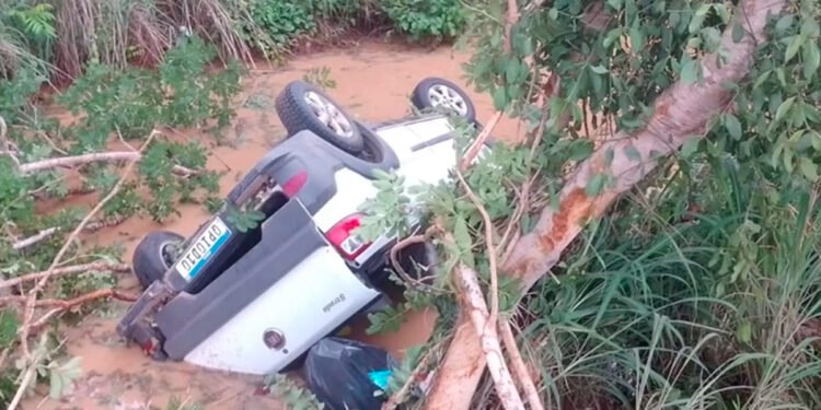 Mulher morre ao ficar presa em cinto de segurança depois de veículo cair em vala coberta por água, em Riachinho