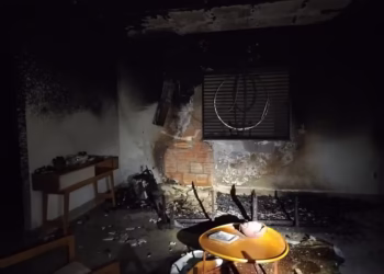 Bombeiros pulam muro para combater incêndio em imóvel de Janaúba